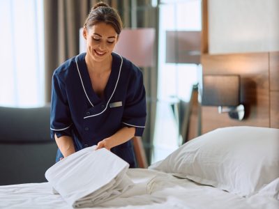 Smiling,Maid,Changing,Bedding,In,Hotel,Room.,Copy,Space.